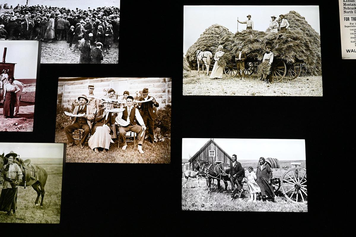A display of historical black-and-white photographs mounted against a black background, showing scenes of early rural life.